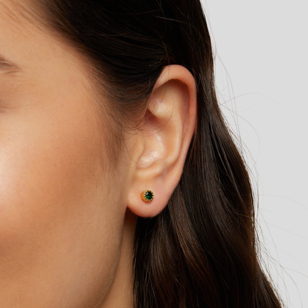 Victoria – Gold earrings adorned with green stones.