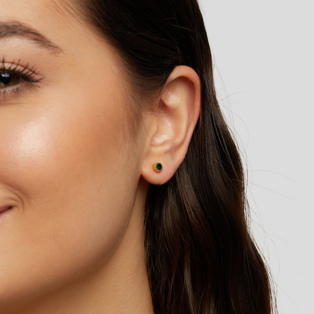 Victoria – Gold earrings adorned with green stones.