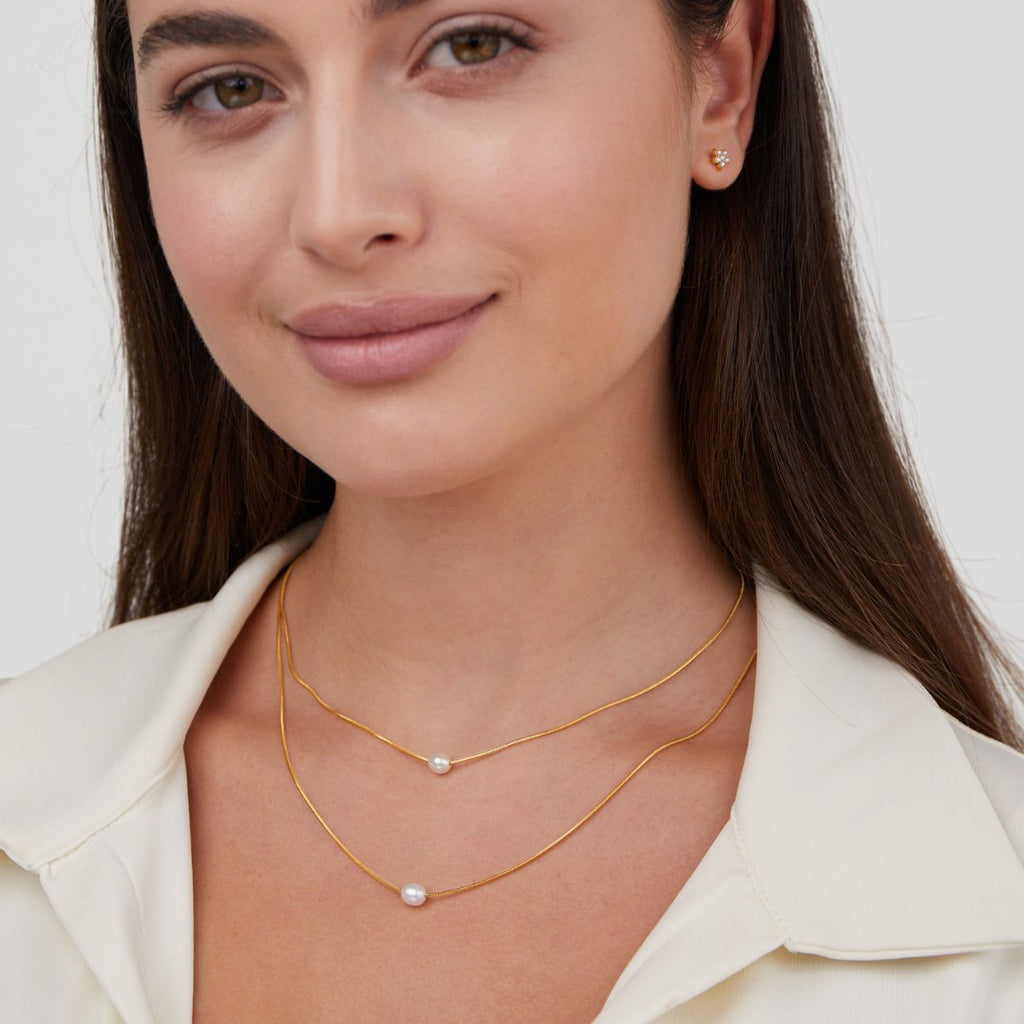 Sabine – Two-layer gold chain with a dark stone.