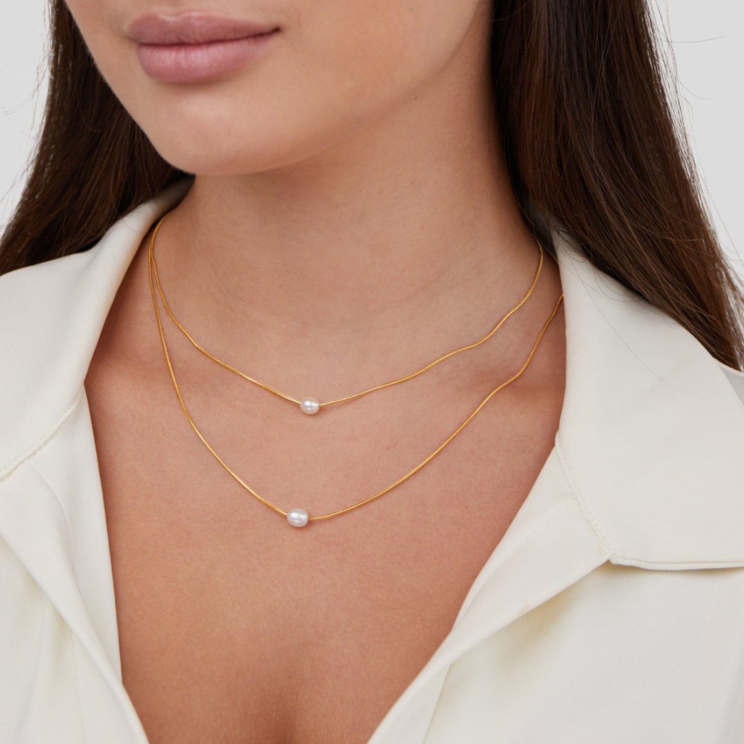 Sabine – Two-layer gold chain with a dark stone.