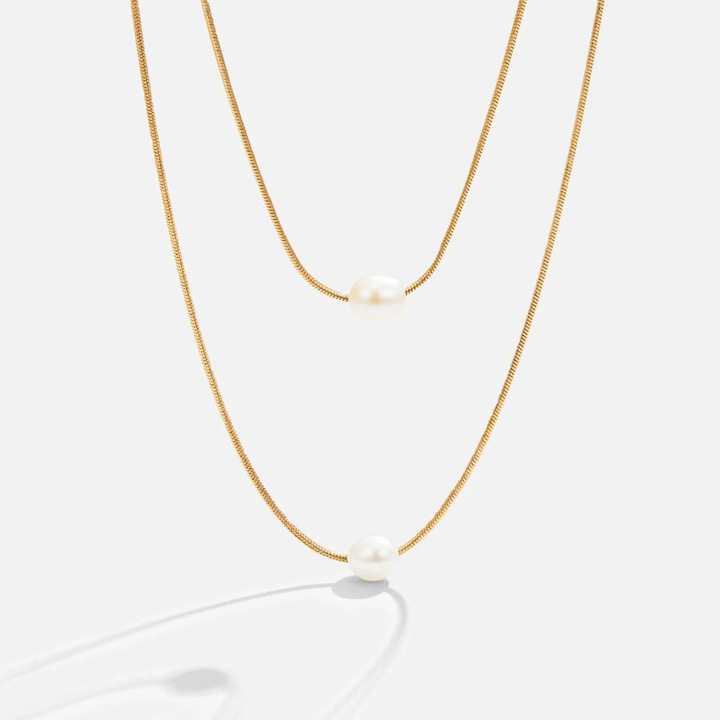 Sabine – Two-layer gold chain with a dark stone.