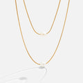 Sabine – Two-layer gold chain with a dark stone.