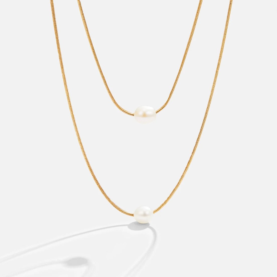 Sabine – Two-layer gold chain with a dark stone.