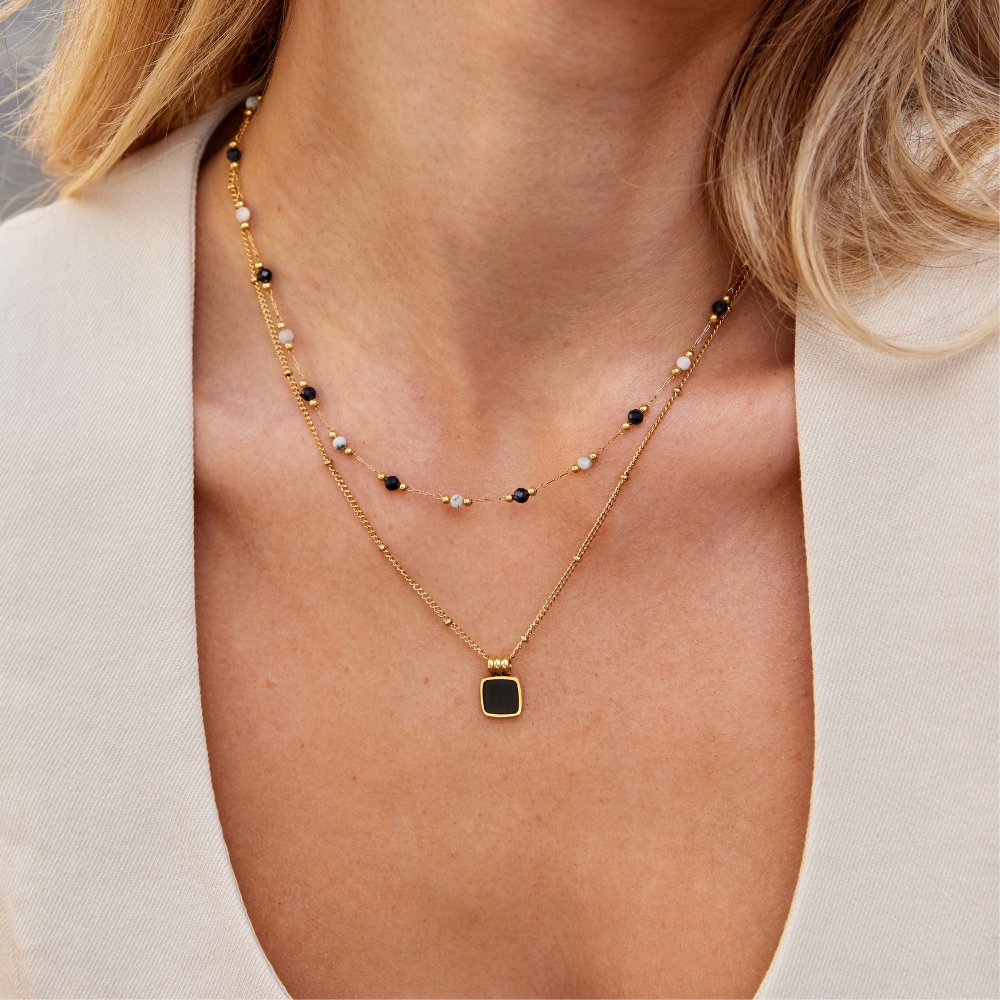 Teresa – A delicate necklace with intricate black and white details.