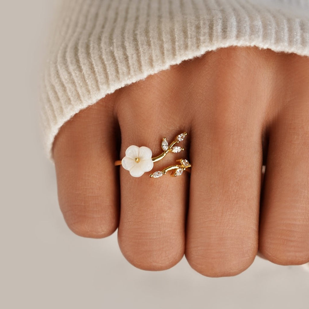 Miriam – An engagement ring adorned with white floral decorations.